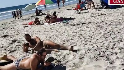 Horny gay couple is having raw sex on a public beach