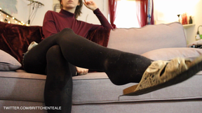 Sandal Shoe dangling in Black Tights