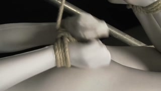 Babe wrapped in white zentai suit enjoys to be bondaged to a metal pole