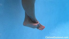 Bare feet and legs underwater and on display in the resort pool