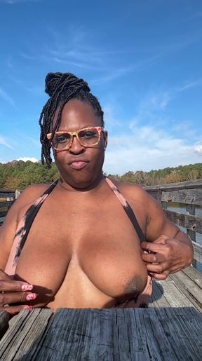 MATURE EBONY GIANTESS SITS ON SUB OUTSIDE   Clip 1