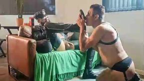 mestre fumando um charuto na sala de estar vestido de couro e chama seu submisso obediente