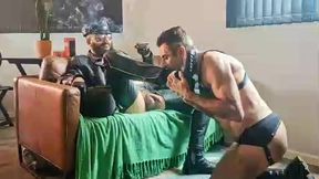 mestre fumando um charuto na sala de estar vestido de couro e chama seu submisso obediente