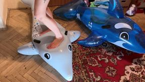 a girl in lingerie with bare feet tramples inflatable whales hard, steps on them, tramples them, walks, crushes, jumps, sits on them, sits on their face foot fetish crash fetish dominance legs