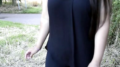 South Asian British woman stands on a grassy path in a quiet public park