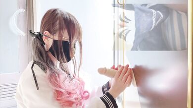 Glasses and pigtails blur as she rams a dildo against the wall