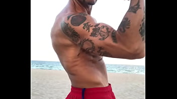 BICEP FLEXING  AT THE BEACH