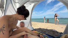My Asian GF sits on a public beach, jerking my cock while I'm naked.