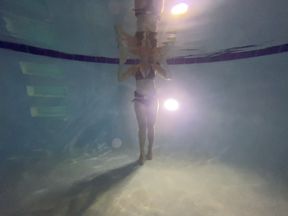 Underwater partial nudity in a public pool with old school weight belt and oval mask