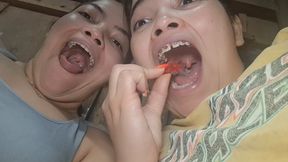 Two giant girls open their mouths wide