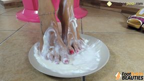 Barefoot brunette covers her feet in sweet cream