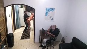 while the husband works, the wife in a towel greets the delivery man.