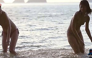 Lesbian Asian and European girlfriends playing in the ocean