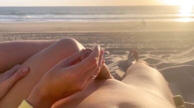 Public handjob on a nude beach with a cumshot caught at sunset
