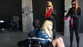 Bound and gagged in shiny puffer jackets these masked dommes gag subs with red cloth