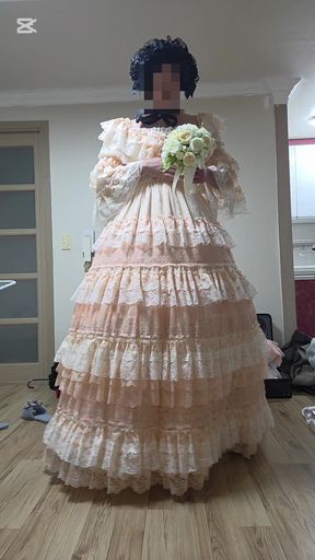 A man dressed as a woman dances in a dress.