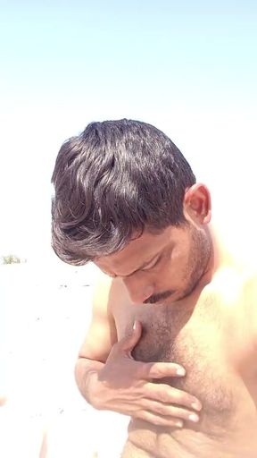 Handsome man rubbing his beutifull body in sunshine