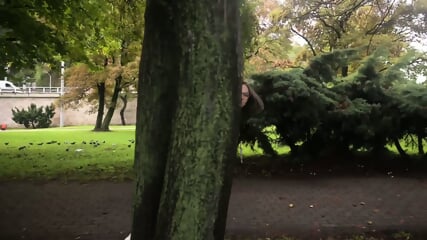 Une femme a la poitrine genereuse s'exhibe dans un parc
