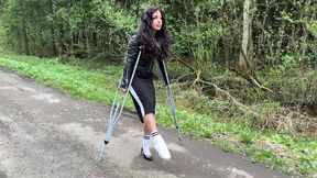 Girl with broken leg walking in crutches