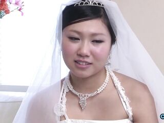 The fresh Oriental bride remains attired in her bridal gown through a visitor's arrival