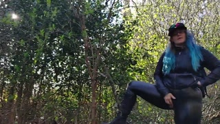 Long haired rocker type woman,in leather,rubs pussy beside busy public road