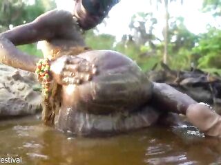 Sexy slim Afro village woman bathing and teasing in a river