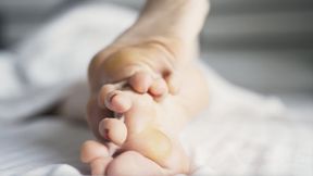 Callused feet relax in bed (4K)