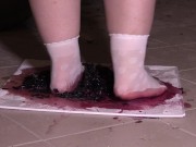 Plump legs in white socks mercilessly trample grapes. Crush fetish