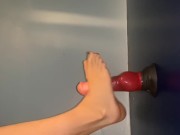 Lubing up and rubbing a dildo with her feet