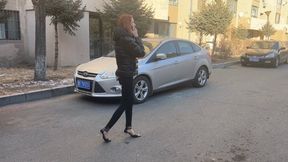 A girl in high-heeled shoes was waiting for her friend at her house and talking on the phone, not noticing the car that crushed her foot and shoe