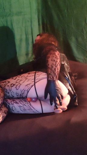 Sissy in leather plays with dildos