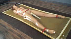 Bondage with red straps in latex bed with vibro