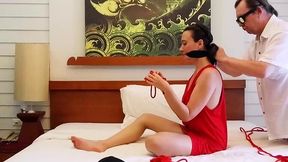 Bondage beauty Sofi gets her hands and legs tied up with red ropes on a comfy bed.