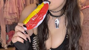 Goth girl inflates small beach balls while wearing black lipstick