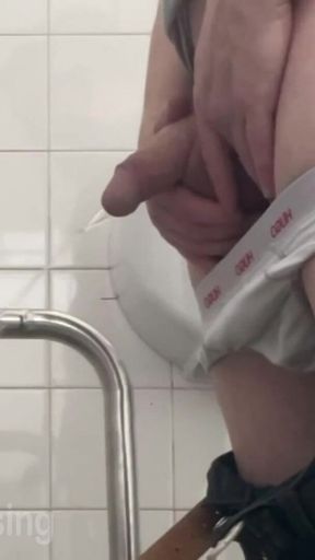 In the Hospital Toilets, a Guy Pisses Into a Cup for a Urine Sample, Then Gets Horny, Jerks-off and Cums