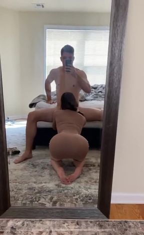 Hot brunette in bodysuit gives a mirror blowjob to her girlfriend