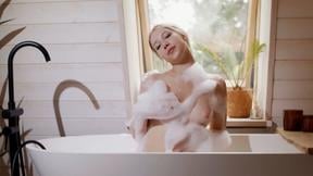 ”Petite blonde teen gets naked in the bathtub to reveal soapy tits”