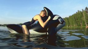 I'm riding a big black inflatable whale on the lake!!!