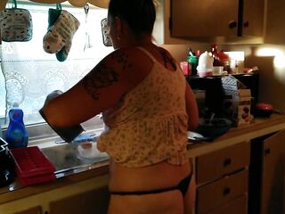 Showing off my cleavage and belt by lifting up my costume whilst cooking in kitchen