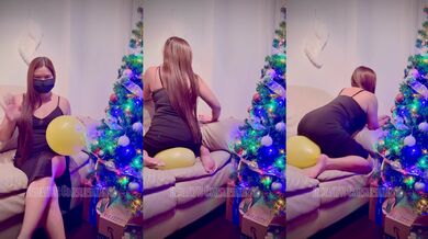 Chubby asian girl plays balloon besides a Christmas tree!