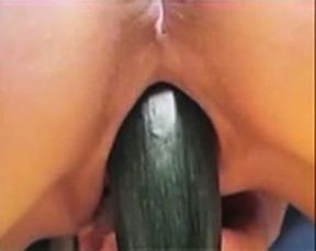 A huge zucchini going in the shaved pink pussy of mine