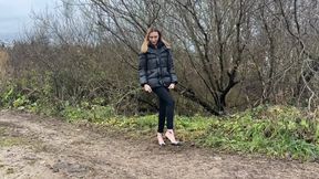 A girl in shiny strappy shoes walked into the deepest mud, which stuck to her shoes and exposed heels