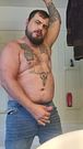 Tattooed man jerks fat cock through the fly