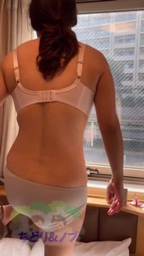 A beautiful Japanese woman getting naked from the hotel window towards the train platform.