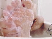 Foot massaging in the bath all wet and soapy