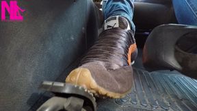 Driving and pedal pumping in brown Nike speakers and blue jeans