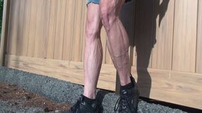 In black sneakers flexing by fence