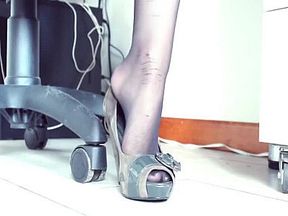 Sexy feet with collant dangling in office
