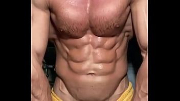 Big muscular body flexes and sprays lotion on his ripped big chest!