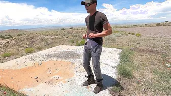 Muscular guy pisses his jeans and work boots in the desert
